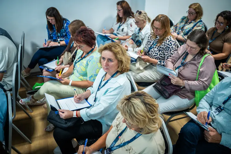 Jegyzetelő résztvevők egy workshopon